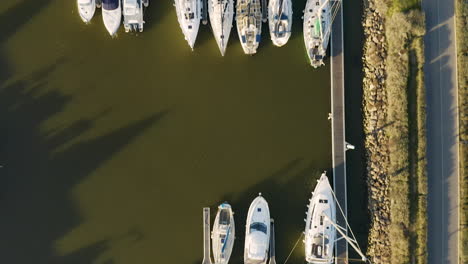 Vertical-aerial-drone-view-over-docked-sailing-boats-Chichoulet-harbor-port